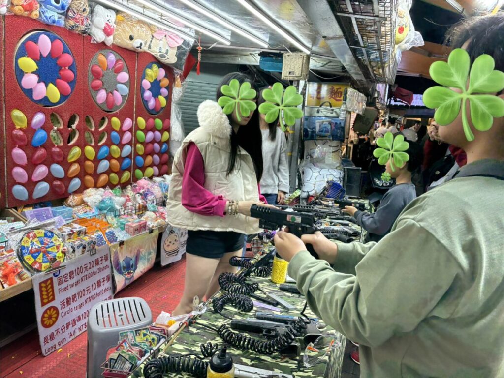 士林夜市の射的屋、的に向かって挑戦する様子
