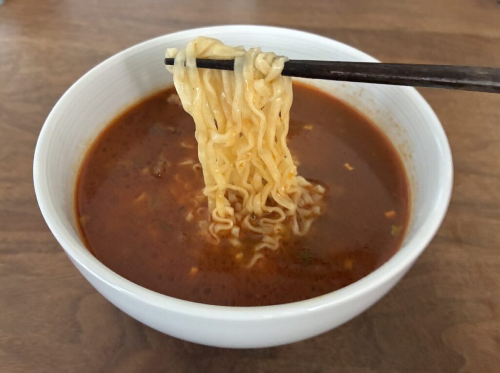 満漢大餐紅焼牛肉麺の麺を持ち上げた様子